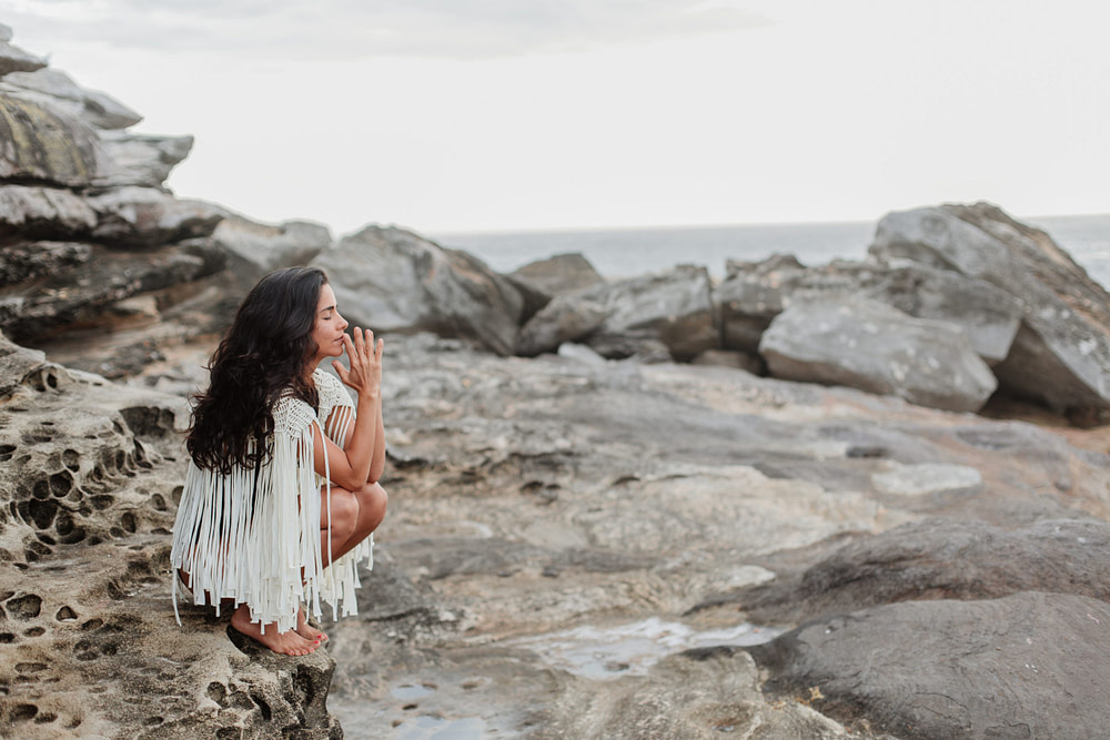 woman doing courageous healing woman sitting on rocky beach