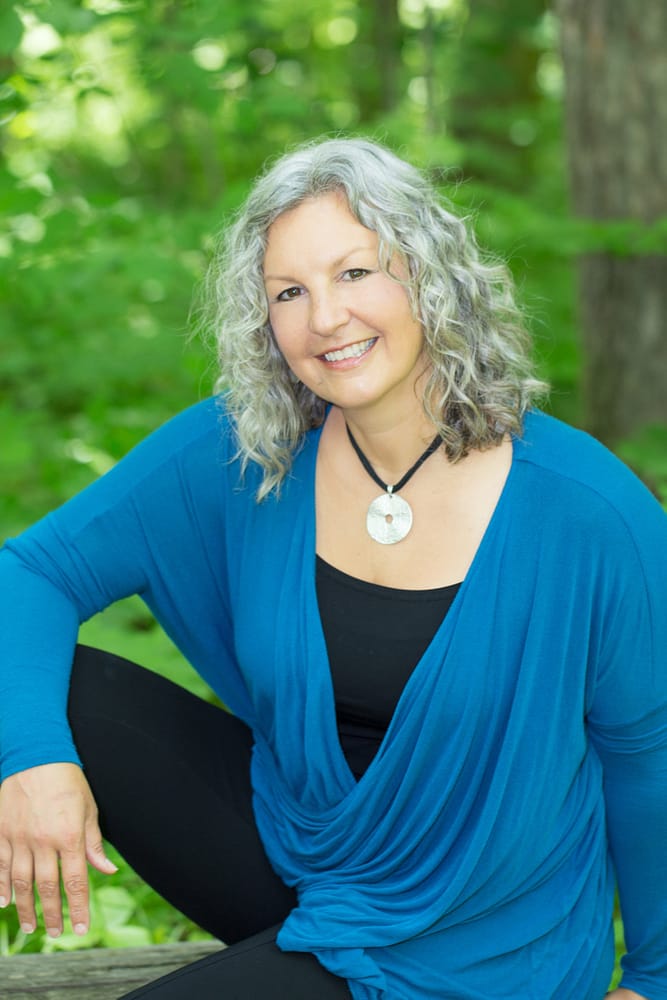 Sue Bowe sue sitting on a bench in the forest